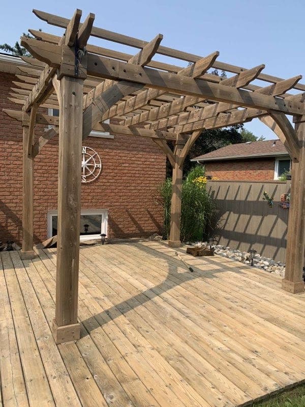 Wide view of a restored deck and pergola after brush-applied staining