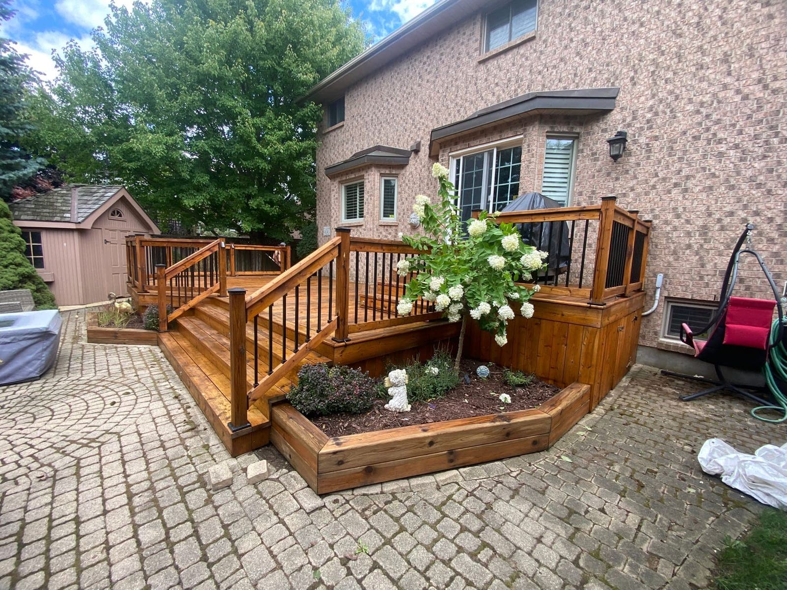 Restored deck with planters behind a brick home